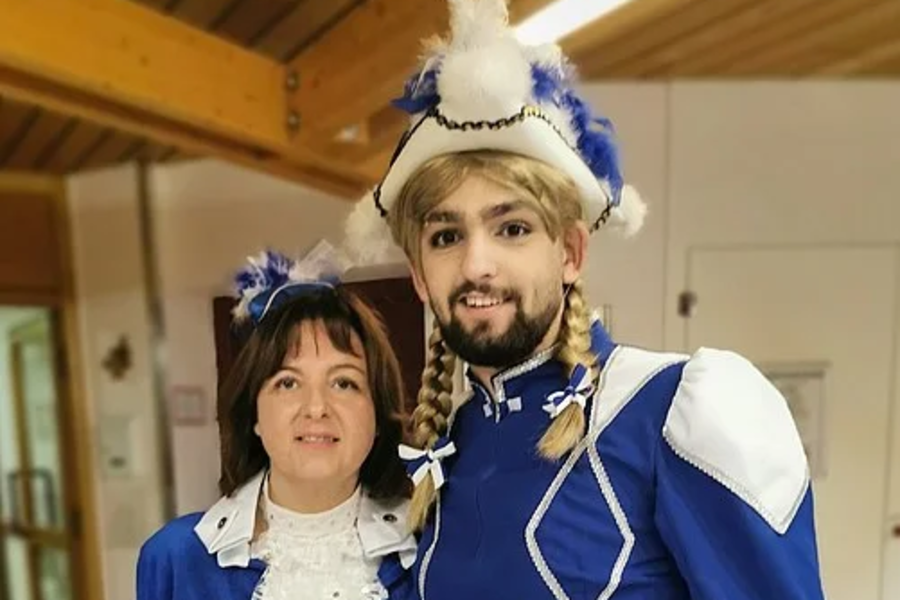 Zwei Personen in blau-weißen historischen Kostümen mit Rüschen und Verzierungen, eine trägt eine Federhaube.