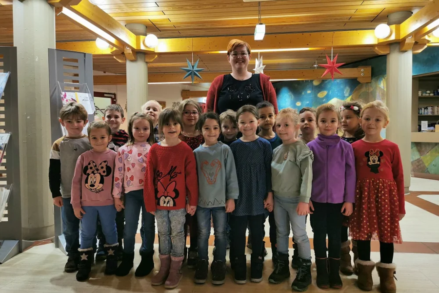 Gruppe von Kindern und einer erwachsenen Person in einem Flur